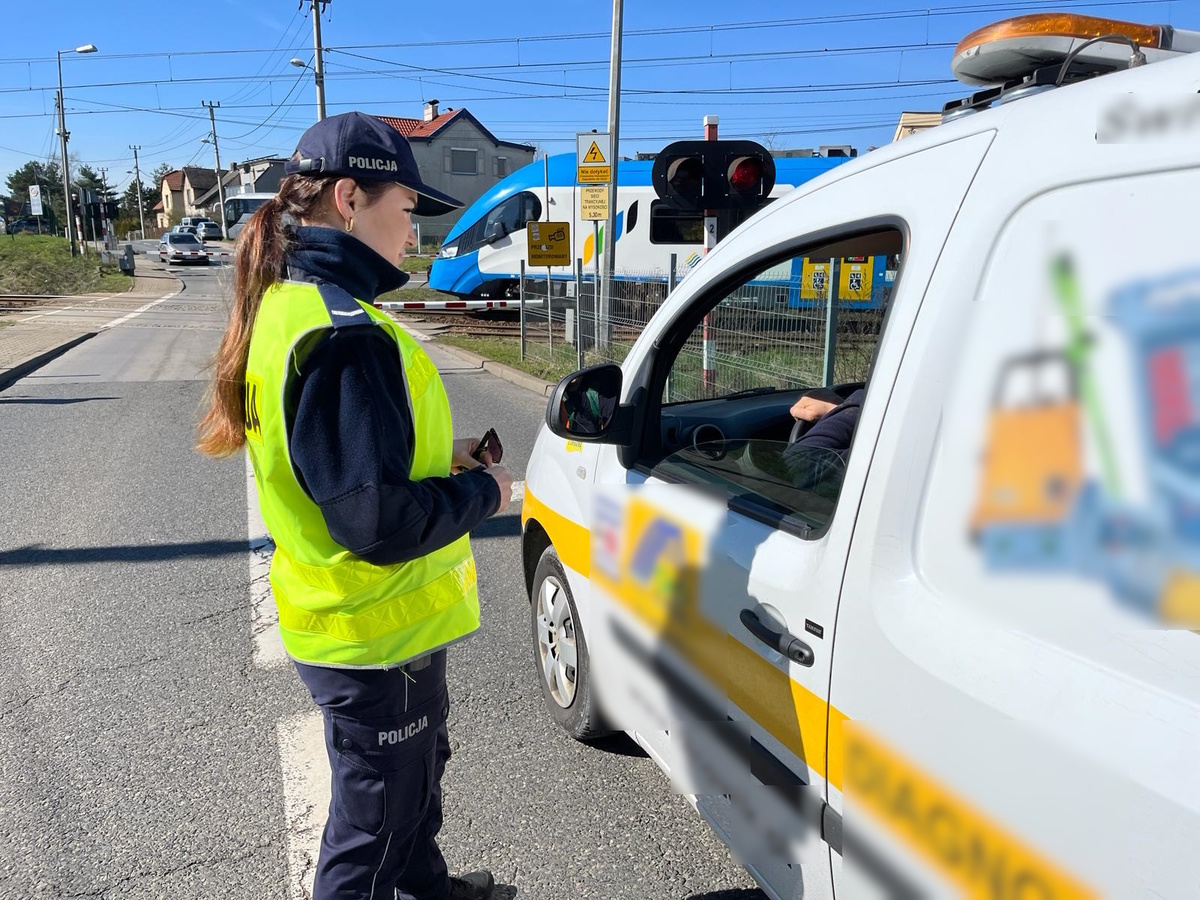 zdjęcie kolorowe: katowicka policjantka rozmawiająca z kierowca samochodu osobowego podczas działań "Zapora życia"