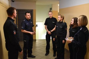 policjanci z Niemiec stoją na korytarzu budynku pomieszczeń dla osób zatrzymanych i rozmawiają z polskimi policjantami