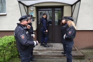 czterech niemieckich policjantów wraz z polskim policjantem przed klatką schodową udają się na interwencję