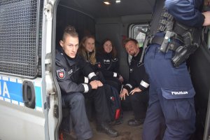 niemieccy i polscy policjanci siedzą w radiowozie typu fiat ducato