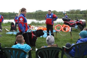 na zdjęciu widać jak ratownicy wodni pokazują psy rasy nowofundland