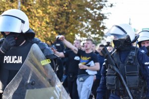 zdjęcie kolorowe: śląscy policjanci podczas zabezpieczenia przemarszu kibiców na mecz GKS Katowice i ELANY Toruń