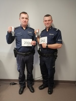 Na zdjęciu widać dwóch policjantów w mundurze z medalami i kartami sportowymi