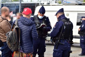 zdjęcie kolorowe: policjanci na katowickim rynku legitymujący osoby bez maseczek ochronnych