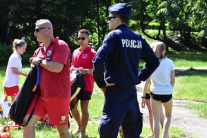 zdjęcie kolorowe: ratownicy wopr i policjant na przystani