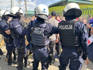 zdjęcie kolorowe: policjanci zabezpieczający przemarsz kibiców na mecz piłki nożnej rozgrywany pomiędzy drużynami GKS-u Katowice i Odry Opole