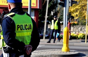 zdjęcie kolorowe: policjanci stojący w rejonie oznakowanego przejścia dla pieszych
